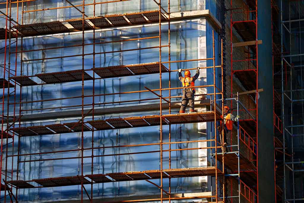 Worker installing scaffolding components